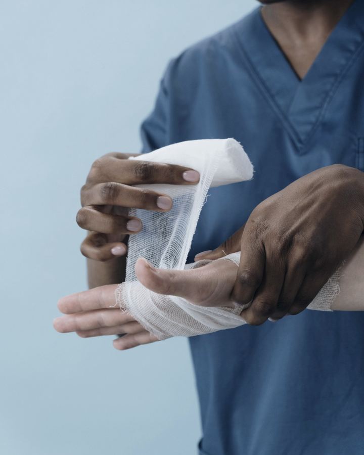 Clinician wrapping a patient’s hand in gauze